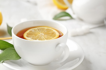 Cup of hot tea with lemon on table