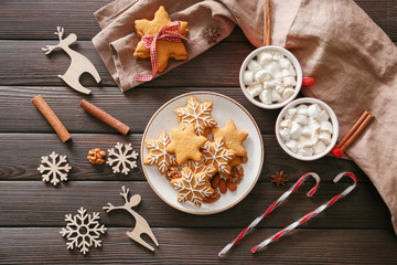 Composition with tasty Christmas cookies and cups of hot chocolate on wooden background