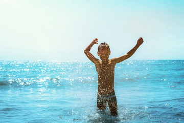 a child running on the seashore with waves