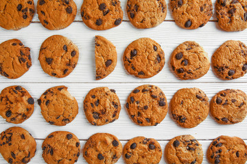 Tasty cookies with chocolate chips on light wooden background