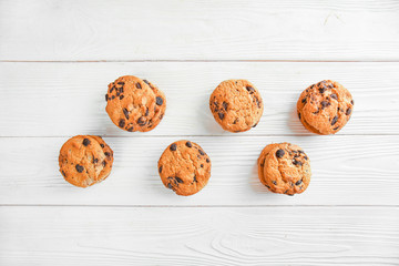 Tasty cookies with chocolate chips on light wooden background