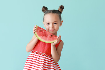Cute little girl with slice of fresh watermelon on color background