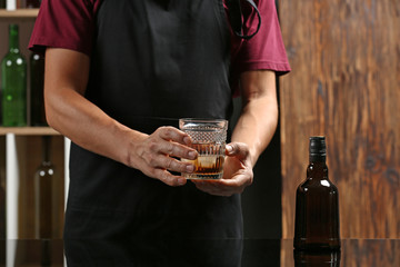 Barman with glass of whiskey in pub