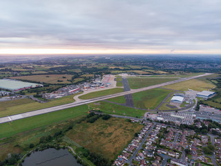 Aerial photo of the famous Leeds and Bradford airport located in the Yeadon area of West Yorkshire in the UK, typical British airport showing the runway and houses and roads around the airport