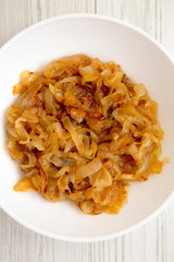 Homemade caramelized onions on a white plate, top view. Flat lay, overhead, from above. Close-up.