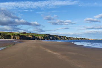 The empty Beach at St Cyrus National Nature Reserve in Aberdeenshire, on one fine Autumn afternoon at low tide, the sands stretching into the Cliffs in the distance.
