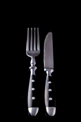 Knife and fork isolated on a black  background. Table cutlery