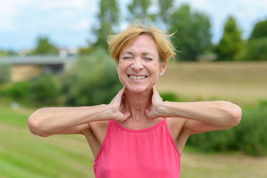 Happy woman stretching with hands to her neck