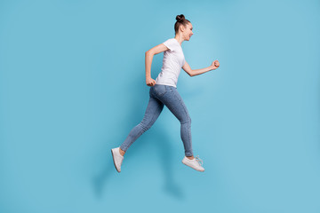 Fototapeta na wymiar Full length photo of excited lady hurrying shopping wear white casual t-shirt jeans denim isolated blue background