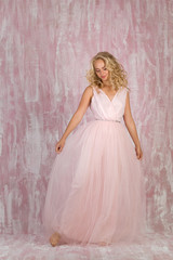 beautiful happy curly blonde woman bride in chic pink dress