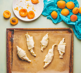 Apricots croissants preparation. Rolled dough on baking sheet . French pastry goods