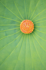 Mooncake in a fresh lotus leaves. Chinese mid-autumn festival food.