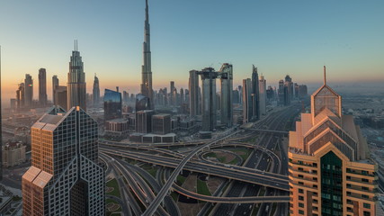 Fototapeta na wymiar Dubai downtown skyline with tallest skyscrapers and busiest traffic on highway intersection night to day timelapse