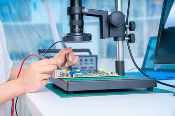 Woman worker in laboratory of electronics devices