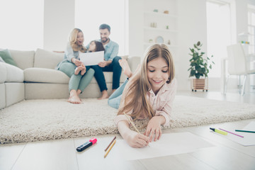 Big adopted family little girl lying floor fluffy carpet ending drawings while parents enjoy...