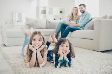Photo of big family two children comfortable lying floor fluffy carpet while parents sit sofa