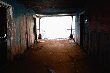 An abandoned rusty corridor with light at the end
