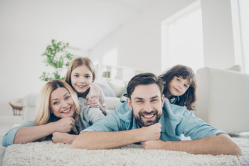 Photo of four members adopted family lying floor toothy smiling fluffy carpet cozy apartments
