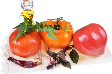 Colorful assortment of fresh  tomatoes ,basil,olive oil on a white background