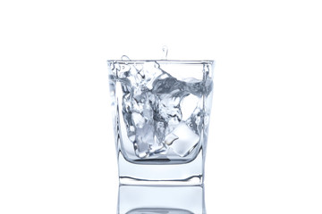 The ice cube splash into glass of water