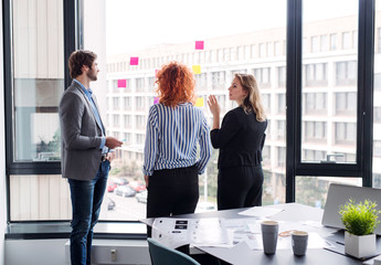 A group of young business people in an office, brainstorming.