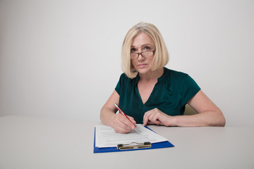 Professional female office worker writing on paper isolated