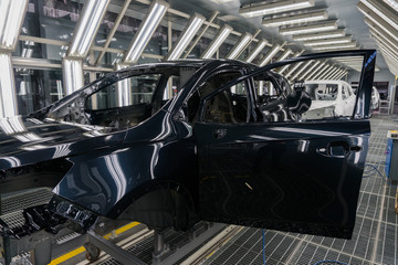 Close-up of the car body after painting at the car factory. Machine Assembly production