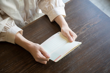 通帳を持つ女性の手元