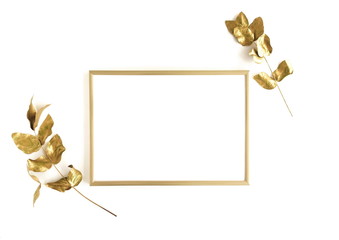 Golden eucalyptus leaves and golden frame mock up om white background isolated top view, flat lay, copy space. Greetings floral minimal card.