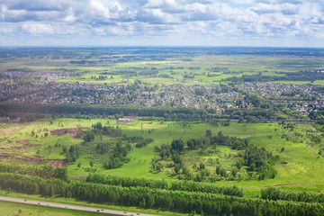 Fototapeta na wymiar Green fields and forests, blue sky and white clouds background panoramic aerial view, sunny summer day europe nature landscape top view, beautiful grassland meadows and trees panorama look from above