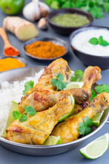 Indian chicken tandoori, marinated in greek yogurt  and spices, served with lime wedges, cilantro and basmati rice, vertical