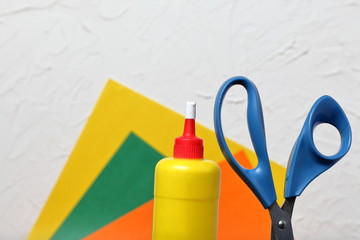Scissors, glue and colored paper for application. They are located vertically. Against the...