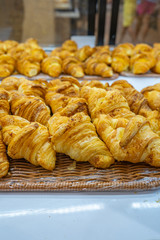 Vertical photo of puffy cheese croissants selling at pastry shop