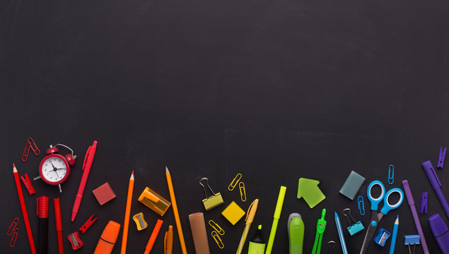 Rainbow of school stationery with copy space above - Powered by Adobe