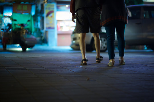 A couple crossin the street at night