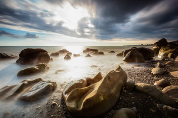 White waves crashing on the rocks at sunset