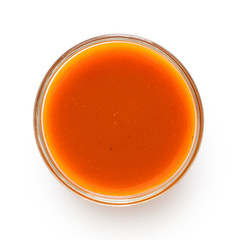 Peri peri chilli sauce in a glass bowl isolated on white from above.