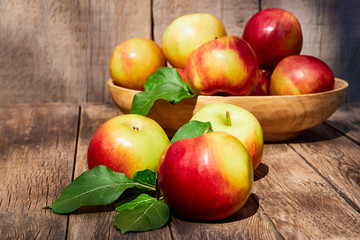 Fresh red apples with green leaves on a wooden old table. On a wooden background. Free space for text. soft focus