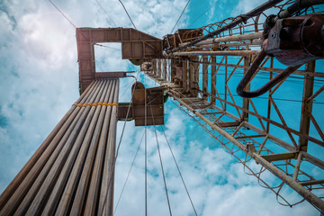 Oil and Gas Drilling Rig onshore dessert with dramatic cloudscape. Oil drilling rig operation on...