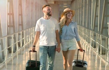 Fototapeta na wymiar Millennial couple going in airport terminal with luggage