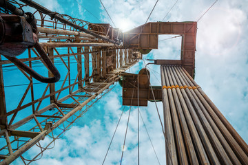 Oil and Gas Drilling Rig onshore dessert with dramatic cloudscape. Oil drilling rig operation on the oil platform in oil and gas industry.