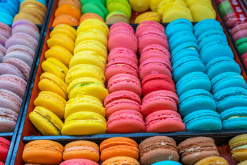 Pile of multicolored French macaroon cakes for sale at bakery