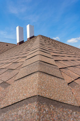 Naklejka premium Asphalt tile roof with chimney on new home under construction