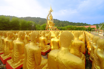 Big lord buddha statue in the middle of thousand golden monk statues