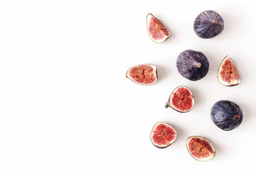 Fresh ripened purple figs. Creative composition, decorative banner of whole and sliced exotic fruit isolated on white table background. Natural pattern. Flat lay, top view. Food photography.