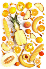 Assorted vegetables and fruits in yellow on a white background. Top view