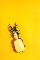 Half ripe juicy pineapple on a yellow background. Top view. Copy space