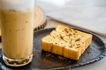A baked bread served with a glass of iced coffee