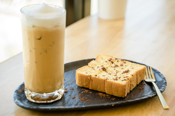 A baked bread served with a glass of iced coffee