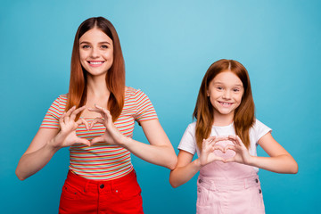 Pretty foxy little lady and her mom making heart figure with hands wear casual clothes isolated blue background